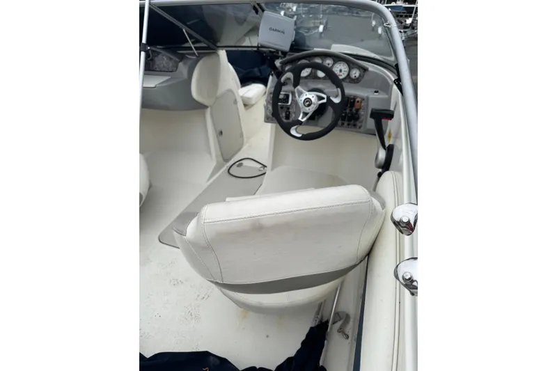 Slide: The Image of Interior of a 2013 Stingray 204 LR boat showing steering wheel and dashboard. - 6
