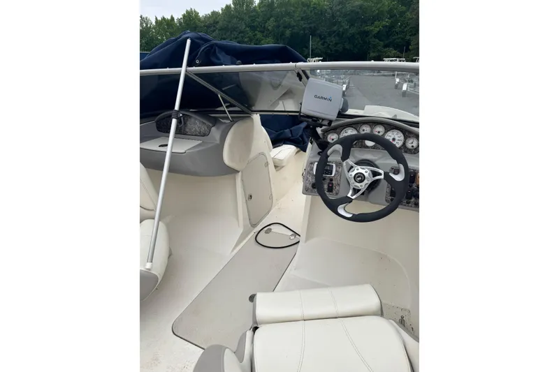 Slide: The Image of Interior of a 2013 Stingray 204 LR boat with steering wheel and Garmin navigation system. - 8