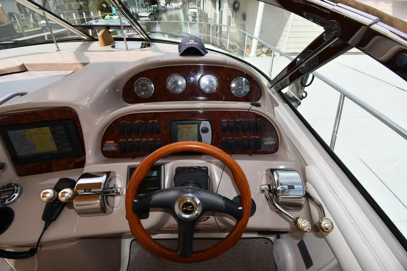 Slide: The Image of Helm of 2003 Sea Ray 360 Sundancer with wood accents and navigation controls. - 12