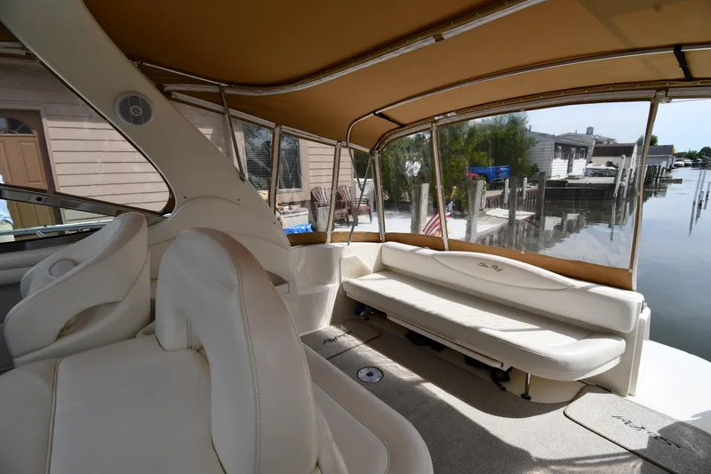 Slide: The Image of Interior of 2003 Sea Ray 360 Sundancer boat with beige seating and waterfront view. - 16