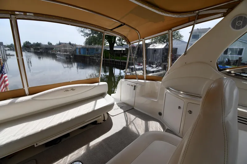 Slide: The Image of Interior view of a 2003 Sea Ray 360 Sundancer yacht with beige seating and waterfront backdrop. - 17