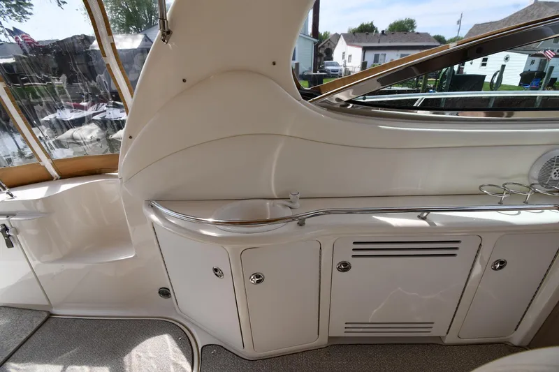 Slide: The Image of 2003 Sea Ray 360 Sundancer interior with sleek cabinetry and window view. - 18