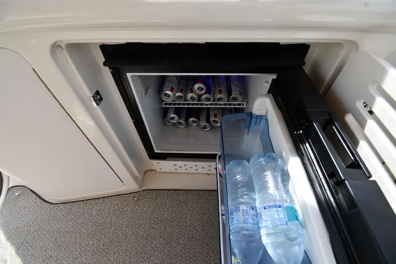 Slide: The Image of Mini fridge on 2003 Sea Ray 360 Sundancer, stocked with drinks and water bottles. - 19