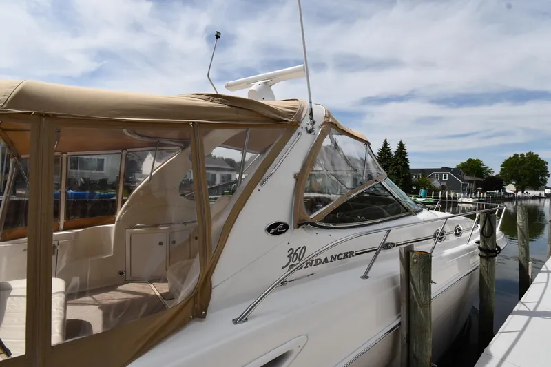 Slide: The Image of 2003 Sea Ray 360 Sundancer docked, featuring tan canopy and sleek design. - 3