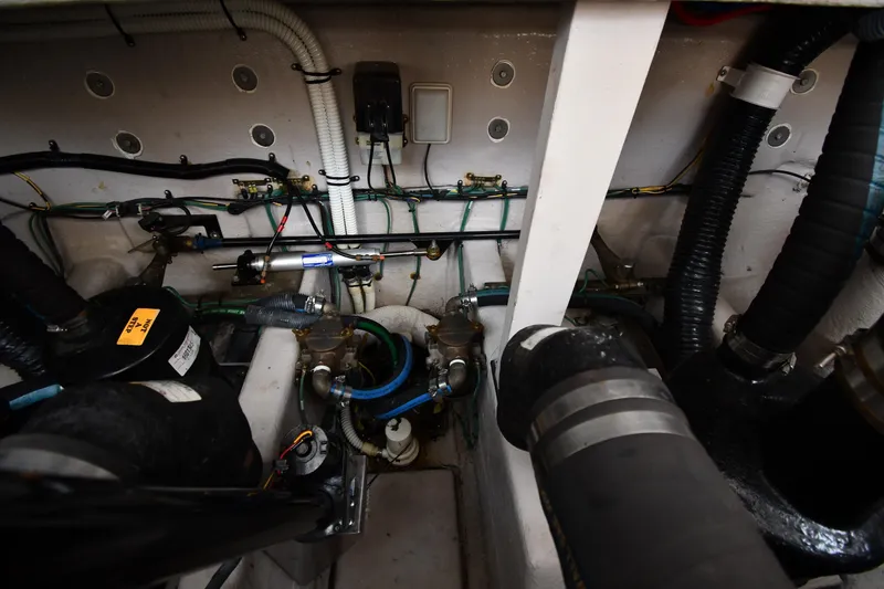 Slide: The Image of Engine compartment of a 2003 Sea Ray 360 Sundancer, showcasing hoses and wiring. - 48