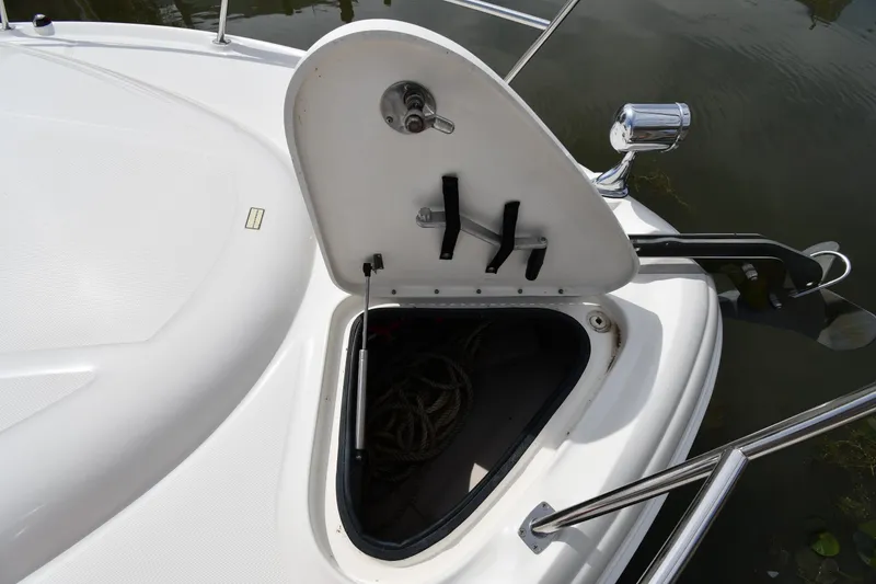 Slide: The Image of Open anchor locker on 2003 Sea Ray 360 Sundancer boat, showing storage space and equipment. - 5