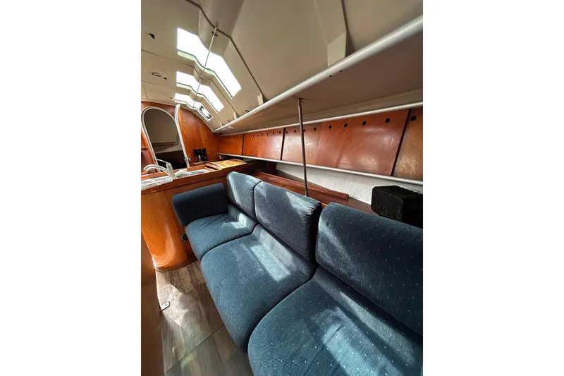Slide: The Image of Interior of 1992 Beneteau First 35s5 yacht with blue seating and wooden accents. - 10