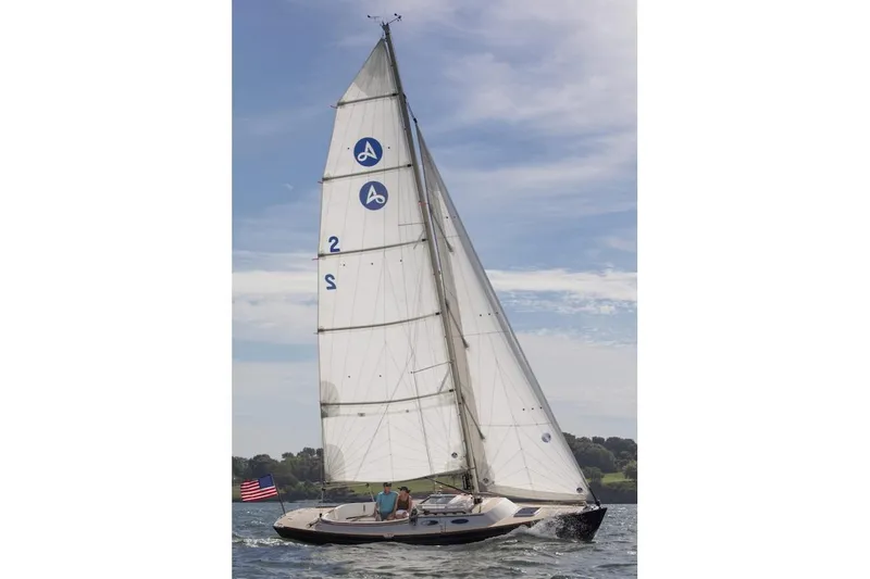 Slide: The Image of 2015 Alerion Sport 30 sailboat on open water, clear sky, American flag. - 4