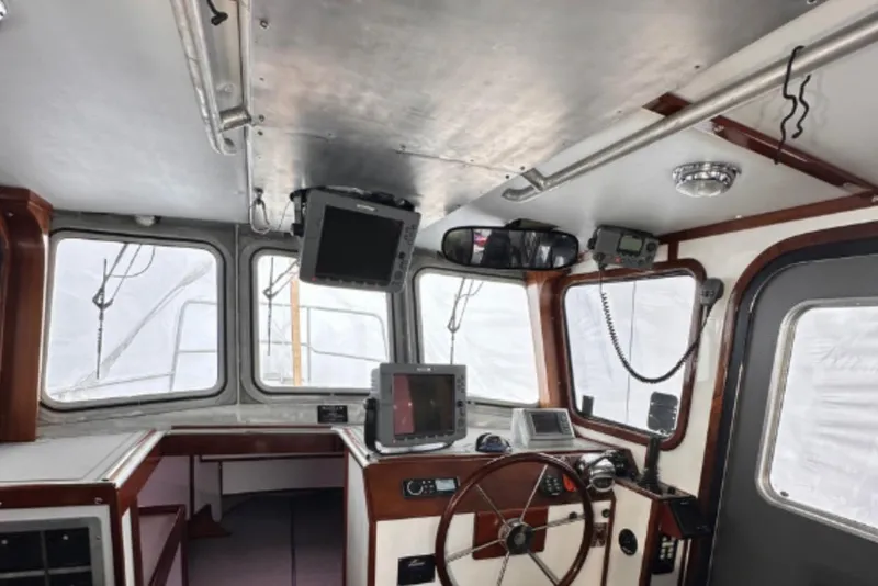 Slide: The Image of Interior of a 2009 Hunt 35 boat cockpit with navigation equipment and steering wheel. - 12