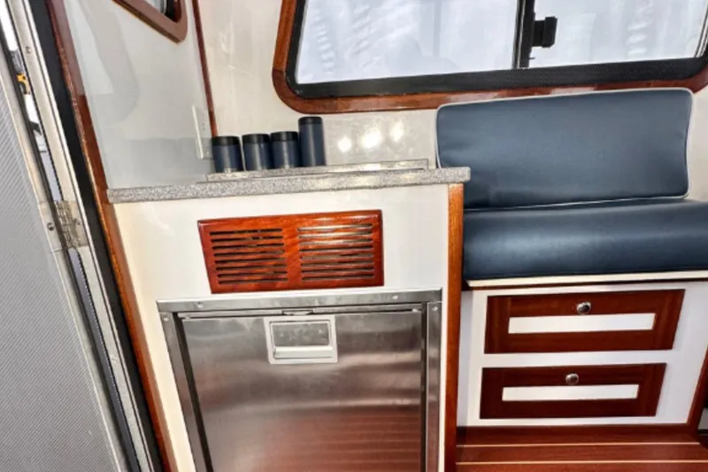 Slide: The Image of Interior of a 2009 Hunt 35 boat with seating, drawers, and a compact kitchenette. - 14