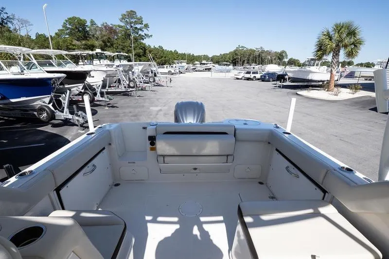 Slide: The Image of 2023 Sailfish 245 DC boat interior at a marina with parked boats. - 10