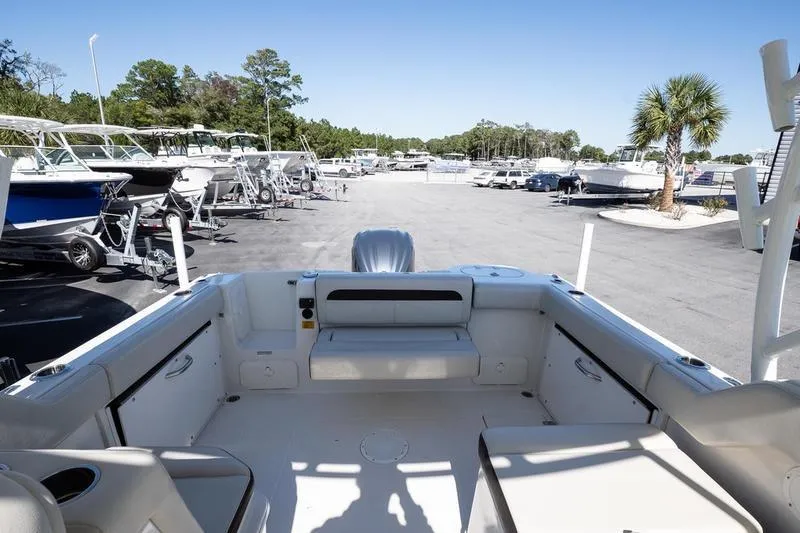 Slide: The Image of 2023 Sailfish 245 DC boat interior at a marina with parked boats. - 11