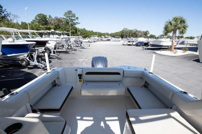 Slide: The Image of 2023 Sailfish 245 DC boat interior with seating, parked in a marina. - 12