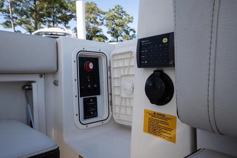 Slide: The Image of 2023 Sailfish 245 DC boat interior control panel with warning label and seating. - 13