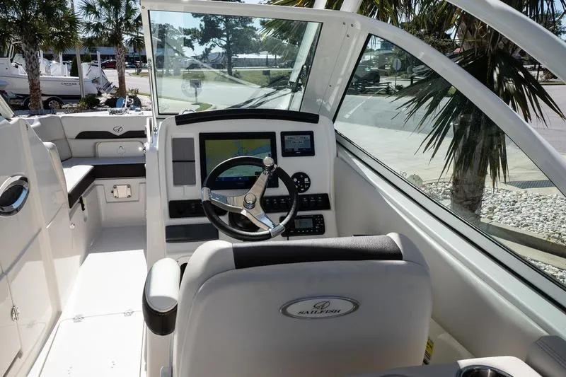 Slide: The Image of 2023 Sailfish 245 DC boat cockpit with steering wheel and navigation system. - 17