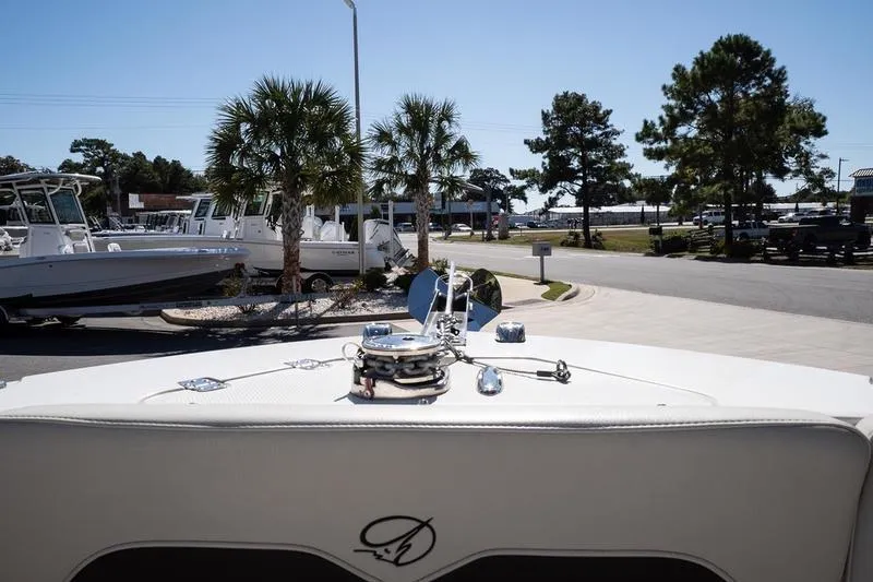 Slide: The Image of 2023 Sailfish 245 DC boat docked, surrounded by palm trees and other boats. - 20