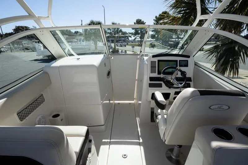 Slide: The Image of 2023 Sailfish 245 DC boat cockpit with steering wheel and seating. - 21
