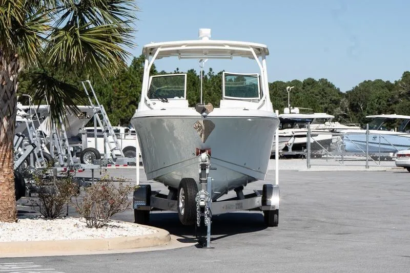 Slide: The Image of 2023 Sailfish 245 DC boat on trailer in a marina parking lot. - 3