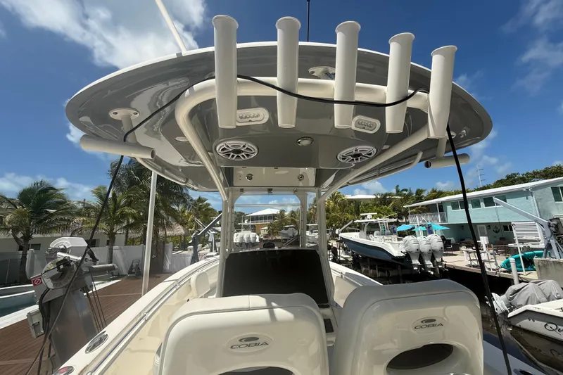 Slide: The Image of 2024 Cobia 280 Center Console boat docked under clear blue sky. - 12