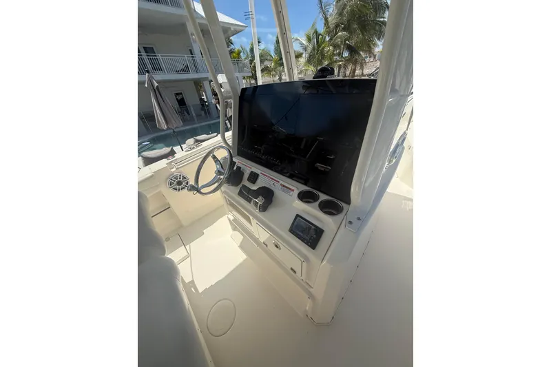 Slide: The Image of 2024 Cobia 280 Center Console boat helm with steering wheel and controls. - 13