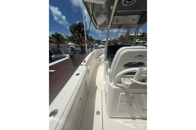 Slide: The Image of 2024 Cobia 280 Center Console boat with sleek design, docked under clear blue skies. - 5