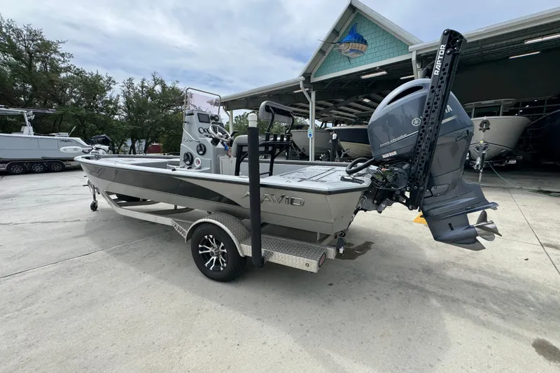 Slide: The Image of 2021 Avid 21 FS boat on trailer, parked outdoors near a marina. - 15
