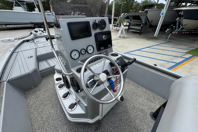 Slide: The Image of 2021 Avid 21 FS boat cockpit with steering wheel and control panel. - 28