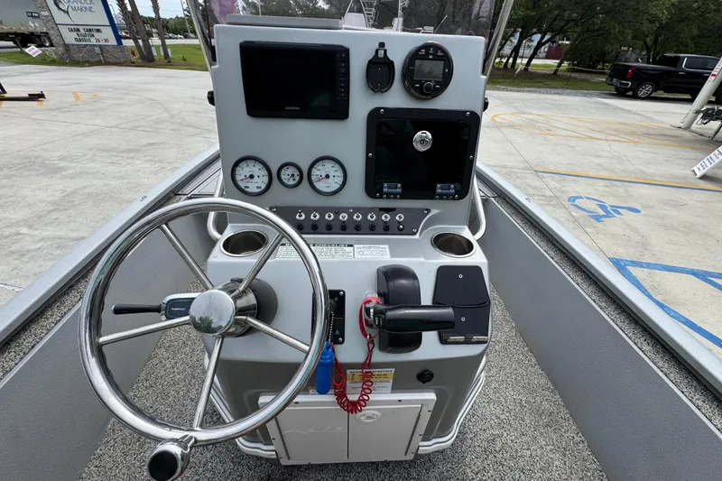 Slide: The Image of Center console of a 2021 Avid 21 FS boat with steering wheel and gauges. - 29