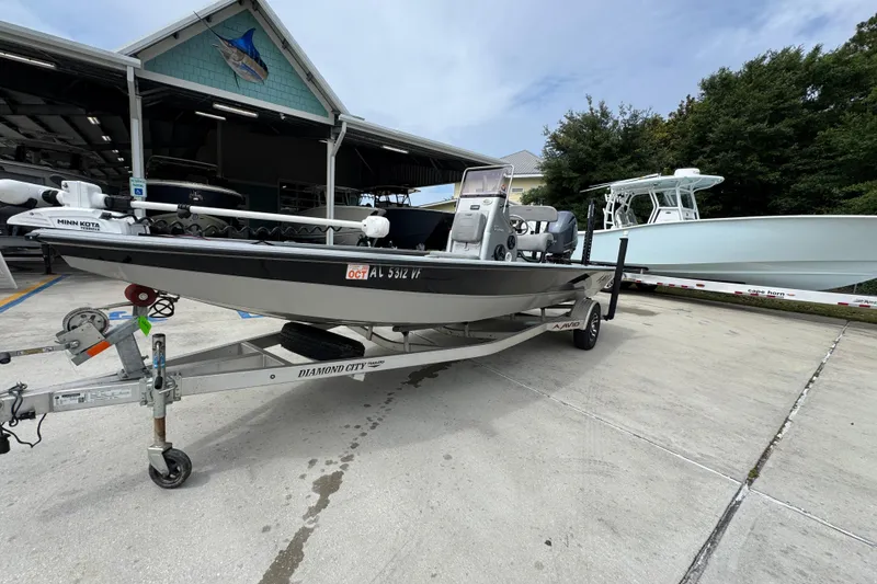 Slide: The Image of 2021 Avid 21 FS boat on trailer, parked outside a marina. - 3