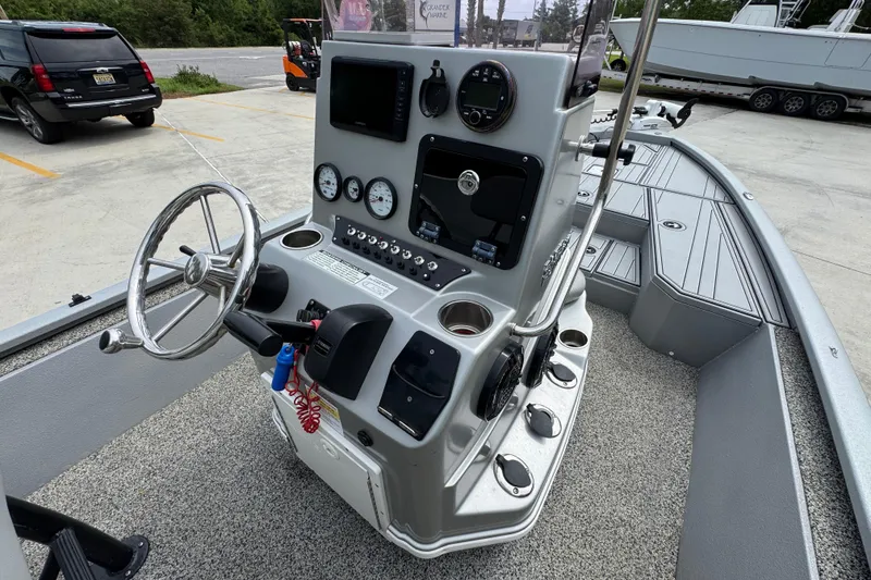Slide: The Image of 2021 Avid 21 FS boat console with steering wheel and gauges in a parking lot. - 30