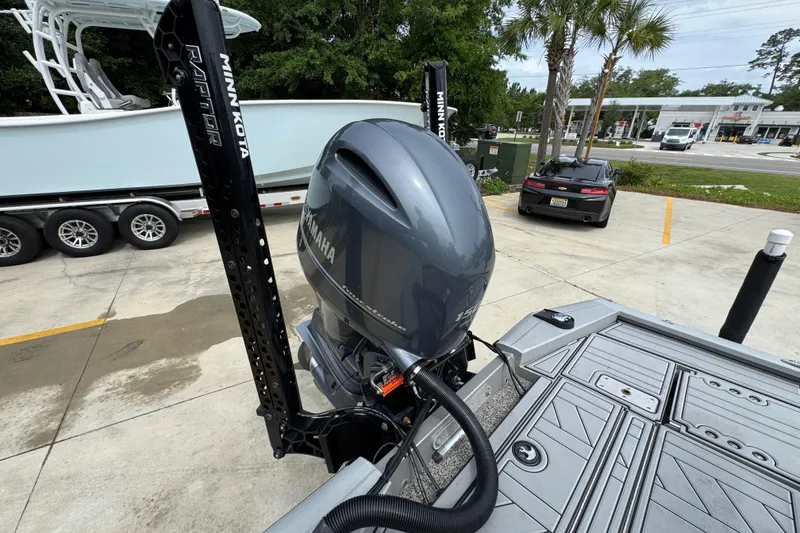 Slide: The Image of Avid 21 FS boat with Yamaha motor and Minn Kota Raptor anchors, parked outdoors. - 33