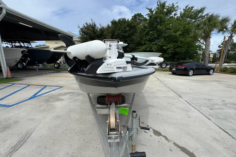 Slide: The Image of 2021 Avid 21 FS boat on trailer with Minn Kota motor, parked outdoors. - 5