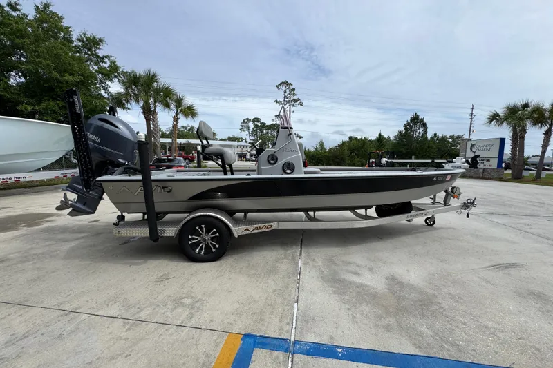 Slide: The Image of 2021 Avid 21 FS boat on trailer with Yamaha engine, parked outdoors. - 9