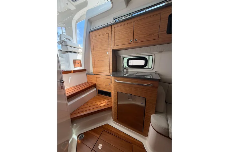 Slide: The Image of Interior of 2022 Boston Whaler 380 Realm with wooden cabinetry and seating. - 10