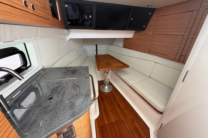Slide: The Image of Interior of 2022 Boston Whaler 380 Realm with kitchenette and seating area. - 12