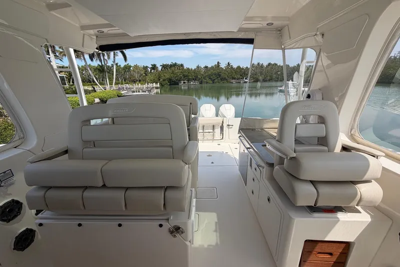 Slide: The Image of 2022 Boston Whaler 380 Realm interior with luxurious seating and scenic water view. - 5