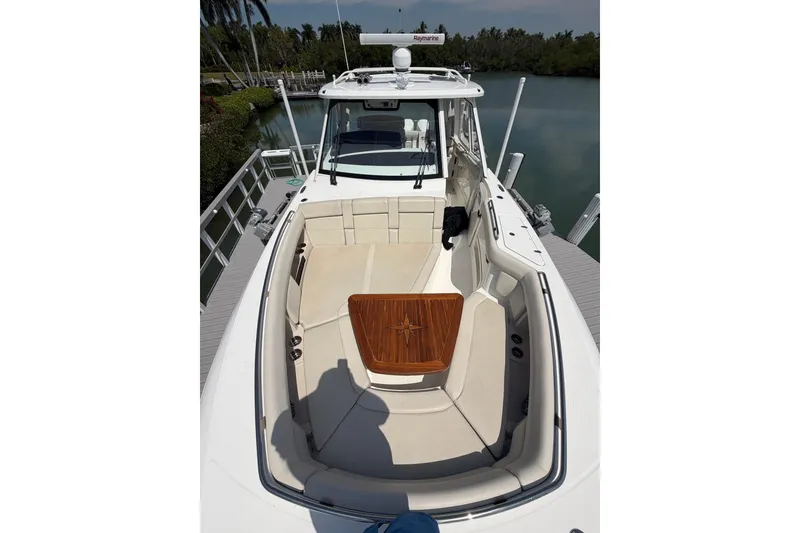 Slide: The Image of 2022 Boston Whaler 380 Realm boat docked, showcasing spacious seating and sleek design. - 7