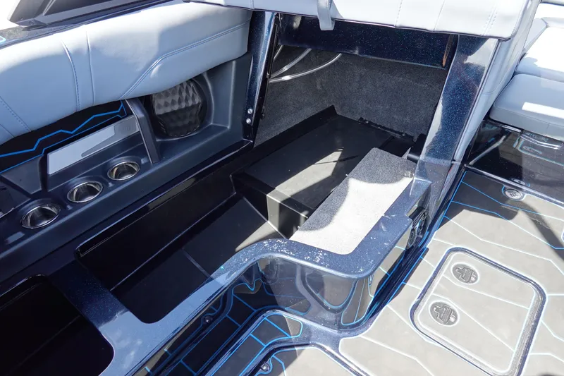 Slide: The Image of 2024 Malibu Wakesetter 23 MXZ interior storage and seating area with cup holders. - 26