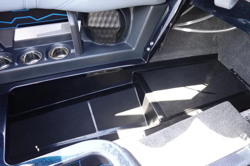 Slide: The Image of 2024 Malibu Wakesetter 23 MXZ interior storage compartment with cup holders and sleek design. - 27