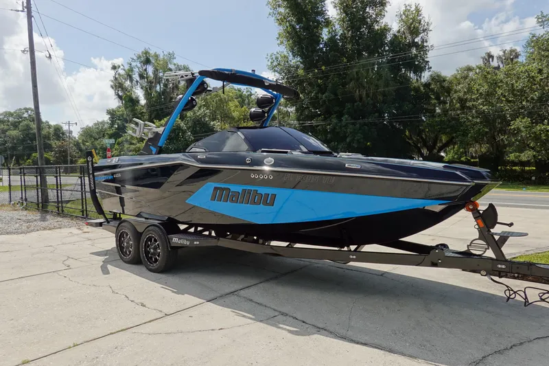 Slide: The Image of 2024 Malibu Wakesetter 23 MXZ boat on trailer, parked outdoors, showcasing sleek design. - 3
