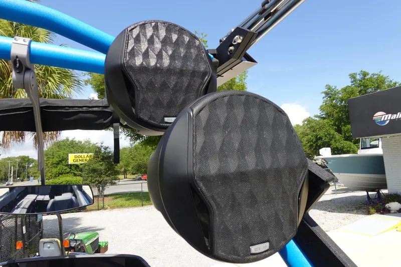 Slide: The Image of 2024 Malibu Wakesetter 23 MXZ boat speakers on blue tower, outdoor setting. - 38