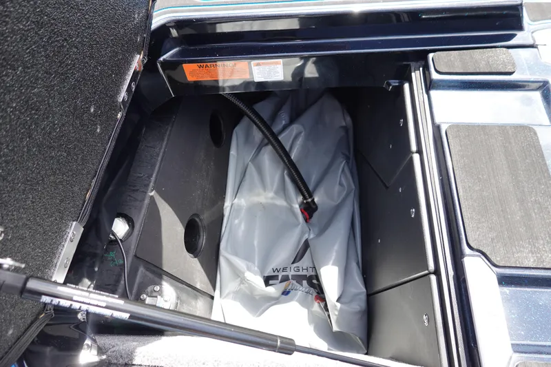 Slide: The Image of 2024 Malibu Wakesetter 23 MXZ ballast compartment with weight bag and hose. - 39