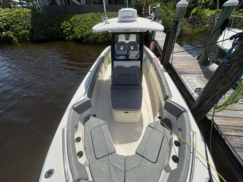 Slide: The Image of 2023 Stingray 273 CC boat docked, featuring spacious seating and Garmin navigation system. - 7