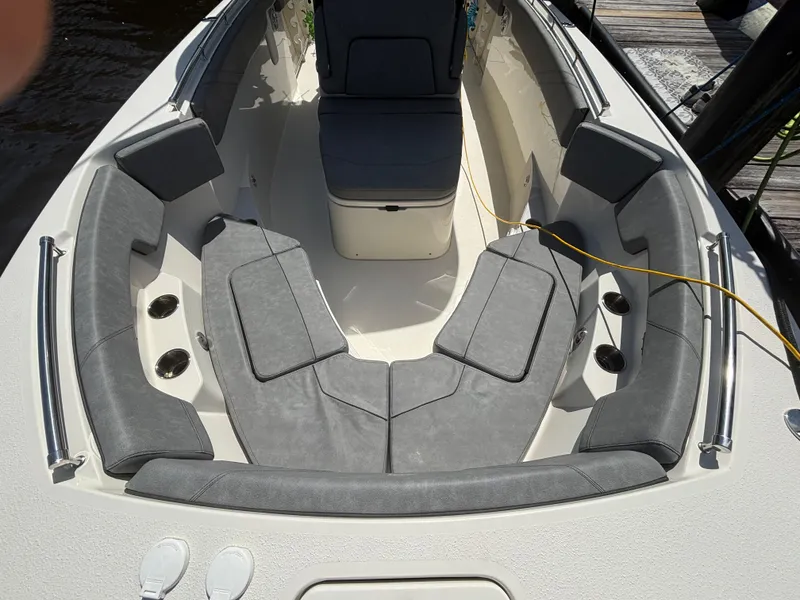 Slide: The Image of 2023 Stingray 273 CC boat interior with gray cushioned seating and cup holders. - 8