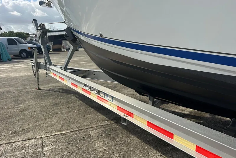 Slide: The Image of 2017 Cobia 296 Center Console boat on Magic Tilt trailer in a parking lot. - 14