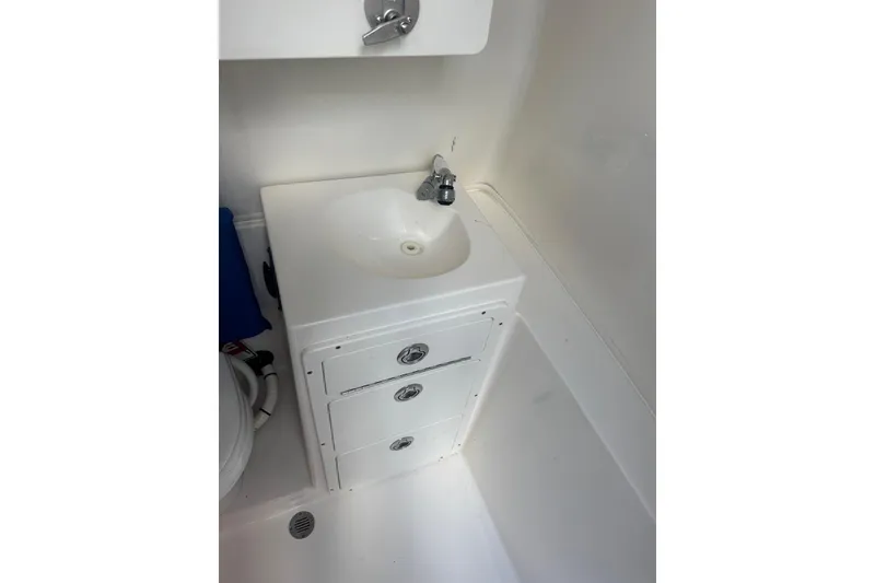 Slide: The Image of 2017 Cobia 296 Center Console boat interior with sink and storage drawers. - 40