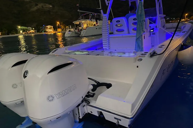 Slide: The Image of 2017 Cobia 296 Center Console boat with Yamaha engines, illuminated at night on water. - 6