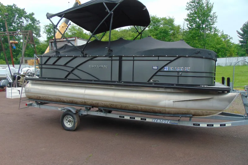 Slide: The Image of 2020 Sylvan Mirage 8520 Cruise pontoon boat on trailer, covered and parked outdoors. - 17