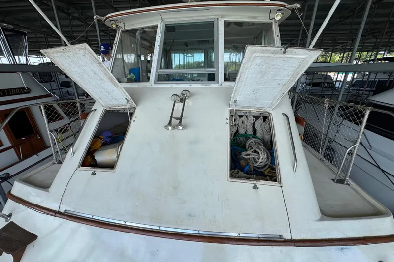 Slide: The Image of 1984 Kadey-Krogen 36 Manatee boat with open storage compartments in a marina. - 10