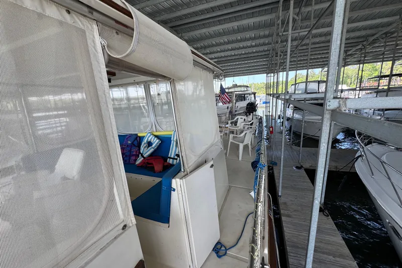 Slide: The Image of 1984 Kadey-Krogen 36 Manatee docked, featuring outdoor seating and covered marina. - 13